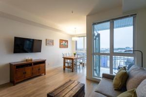 a living room with a couch and a flat screen tv at Urban Stay With Balcony And In-Unit Laundry in Victoria