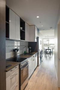 a kitchen with white cabinets and a dining room at Urban Stay With Balcony And In-Unit Laundry in Victoria