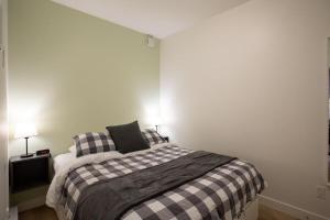 a bedroom with a bed with a checkered blanket at Urban Stay With Balcony And In-Unit Laundry in Victoria