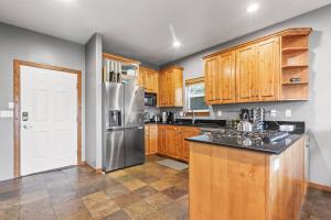 a kitchen with wooden cabinets and a stainless steel refrigerator at Bear Hollow Village 5458 by Moose Management in Park City