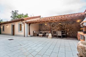 a pavilion with a table and chairs on a patio at La Corrolada de Ana in Debodes
