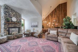 sala de estar con sofá y chimenea de piedra en Wapiti View 6-Bedroom Cabin 28mins to Yellowstone en Island Park
