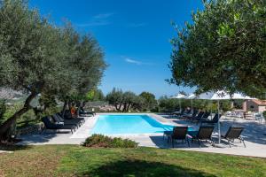 - une piscine avec des chaises longues et des parasols dans l'établissement Eliathos Residence Houses, à Archanes
