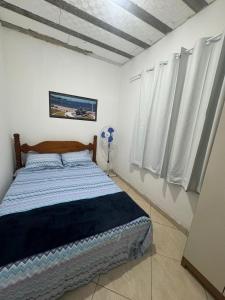 - une chambre avec un lit et des murs et des rideaux blancs dans l'établissement hospedagemsaopedro apartamento com garagem a 13 km de Cabo frio 22 km de arraial do cabo, à São Pedro da Aldeia