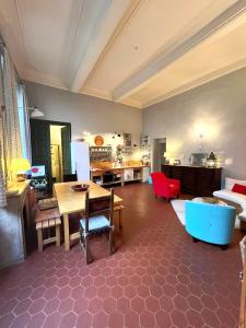 a large living room with a table and a kitchen at Palais des Papes - Spacious Historic Apartment in Private Mansion ! Free PARKING Nearby ! Spacieux Appartement Historique dans Hôtel Particulier ! PARKING à proximité Offert ! in Avignon