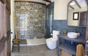 y baño con ducha, aseo y lavamanos. en Finca Valle Verde en Alora