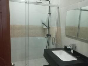 W łazience znajduje się szklana kabina prysznicowa i umywalka. w obiekcie Wisroc Oasis w mieście Linden