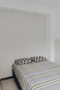 - une chambre dotée d'un lit avec un mur blanc dans l'établissement Recanto Kitnet, à Lagoa Santa