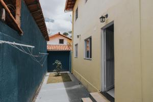une ruelle étroite entre deux bâtiments avec une porte et un arbre dans l'établissement Recanto Kitnet, à Lagoa Santa