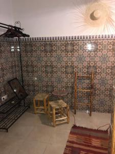 Cette chambre dispose de 2 chaises et d'une télévision murale. dans l'établissement Flottement Des Songes, à Marrakech