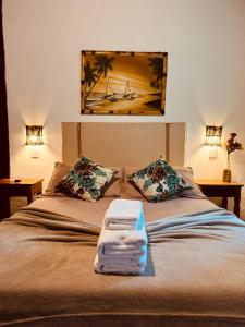 1 dormitorio con 1 cama con toallas en Vila Pequeá Pousada Ilhabela en Ilhabela