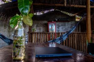 einen Tisch mit einer Vase auf einem Tisch mit einem Laptop in der Unterkunft Padang Hostel in Pipa