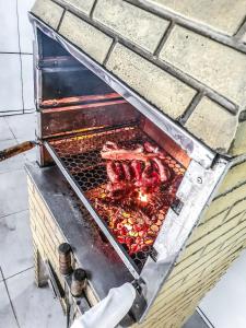 una griglia con carne e altri prodotti alimentari di Casa Do Mar - Wi-fi - Netflix - Piscina a Mongaguá