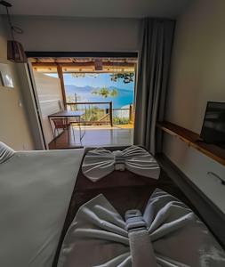 um quarto com uma cama com um laço em Casa Varandas - Estúdio Budião (Tv+Frigobar+A/C) em Ubatuba