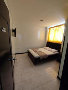 ein Schlafzimmer mit einem Bett in einem Zimmer mit einem Fenster in der Unterkunft Hotel Cinema in Bucaramanga