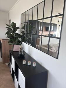 a living room with a black table and a mirror at Appartement T2 en résidence privée in Maurepas