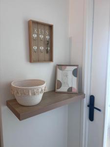 a shelf with a basket and a picture and a clock at Appartement T2 en résidence privée in Maurepas