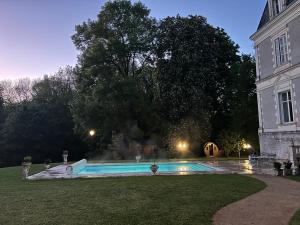 a swimming pool in a yard next to a building at Château de Saint-Bohaire in Saint-Bohaire