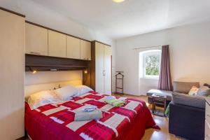 a bedroom with a bed with a red and white blanket at House Gioia Cristina in Labin