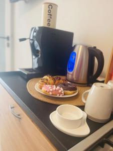 a table with a plate of donuts and a coffee maker at Casa9cento in Omegna +11 photos