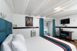une chambre avec un lit blanc et un bureau dans l'établissement Hotel Hacienda Cusco Plaza, à Cusco