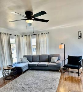 sala de estar con sofá azul y ventilador de techo en Modern La Cresta, en Bakersfield
