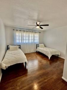 Un dormitorio con dos camas y un ventilador de techo. en Modern La Cresta, en Bakersfield