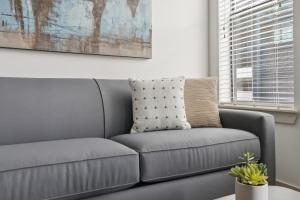 un canapé gris dans un salon avec un tableau dans l'établissement Kasa At Artisan Music Row Nashville, à Nashville