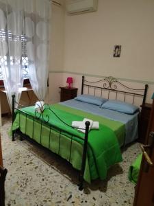 - une chambre avec un lit et une couverture verte dans l'établissement Villa Vitiello, à Torre Annunziata
