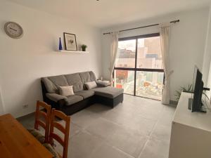 sala de estar con sofá y ventana grande en Holiday Home & Rooftop Lounge, en Las Palmas de Gran Canaria