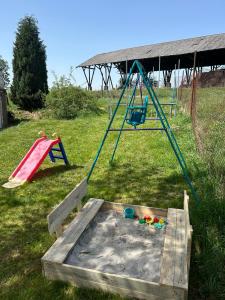 um parque infantil com dois baloiços e um escorrega em Ubytování Háj em Jindřichovice