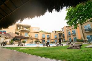 a courtyard with tables and chairs in front of a building at Hotel Natural Hill's by H&R in Villeta