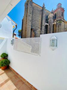 una valla blanca con un edificio en el fondo en Almocabar Luxury Apartment en Ronda