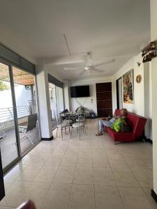 a person sitting on a couch in a living room at Apartamento 2 habitaciones aire acondicionado en Sopetran Unidad res Piscinas sol y descanso in Sopetran