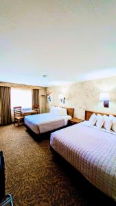 une chambre d'hôtel avec deux lits et un canapé dans l'établissement Browns Canyon Inn, à Salida
