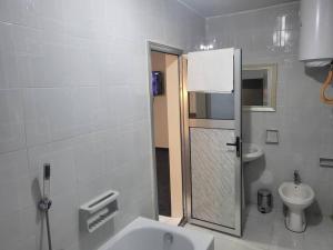 a white bathroom with a sink and a toilet at Hôtel particulier HP in Conakry