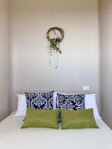 a bed with green pillows and a wreath on the wall at Podere Mantignano in Faenza +21 photos