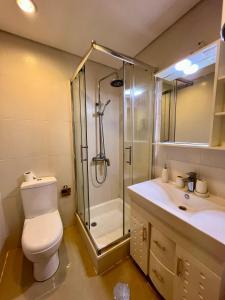 a bathroom with a shower and a toilet and a sink at Ilha Flats in Luanda Beach in Luanda