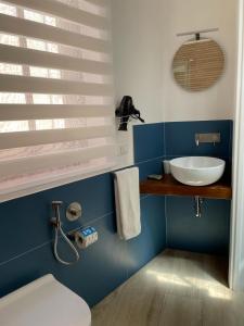 een badkamer met een witte wastafel en een toilet bij Casa dei Mulini in Favignana