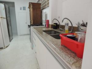 a kitchen counter with a sink and a refrigerator at room itaim in Sao Paulo
