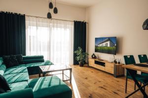 a living room with a green couch and a table at Apartmány Na Vŕšku in Kežmarok