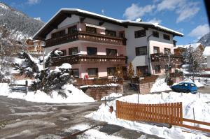 a large building with snow in front of it at Residence Weiss in Vigo di Fassa