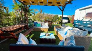 um pátio com sofás, uma mesa e uma caravana em Caravanas Con Encanto El Palmar 2 em El Palmar