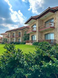 a large building with balconies on a green field at BURHAN'S HOTEL in Rizokarpaso