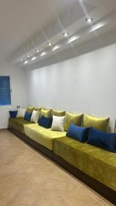 - un long canapé vert dans une chambre avec des oreillers bleus dans l'établissement Kabila vista n4 vue piscine, à M'diq