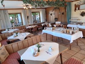 an empty restaurant with tables and chairs and tablesktop at Hotel Garni Edelweiß in Siegsdorf