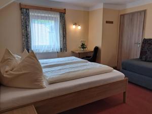 sypialnia z dużym łóżkiem i oknem w obiekcie Hotel Garni Edelweiß w mieście Siegsdorf