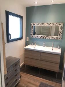 ein Badezimmer mit Waschbecken und Spiegel in der Unterkunft Ty Bihan - Cœur de bourg in Saint-Gildas-de-Rhuys + 22 Fotos