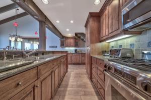 a large kitchen with wooden cabinets and stainless steel appliances at Lakeland Village 610 Lakefront Beauty On Water in South Lake Tahoe