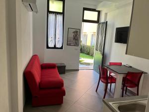 uma sala de estar com uma cadeira vermelha e uma mesa em Casa Lilla em Cannobio